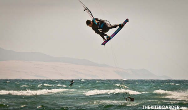 Brian schwarz of CaliKites throws a kite loop and a grab in Pismo.