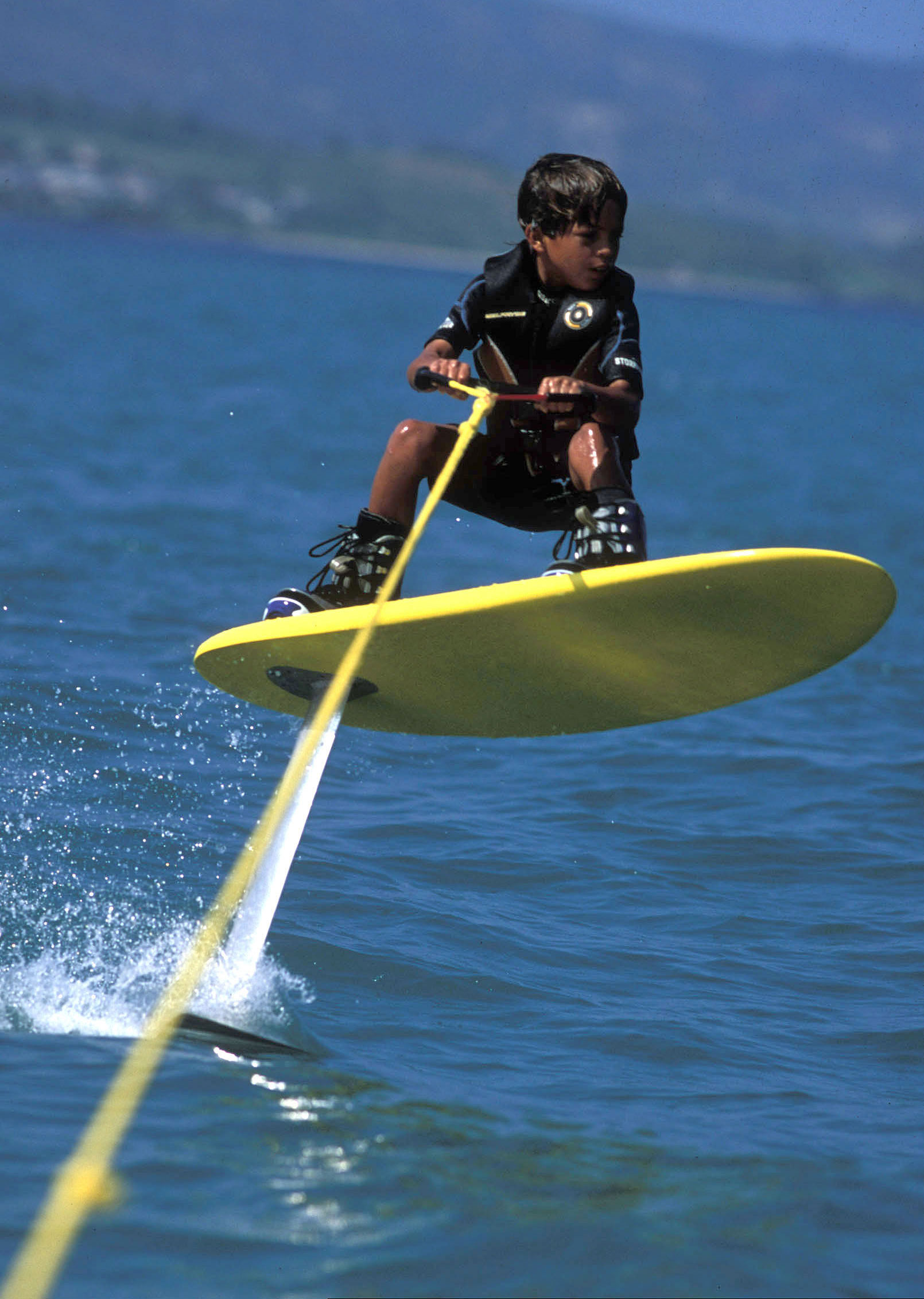 Nine-year-old Kai Lenny learning how to foilboard, boots and all, during the Laird days. Ironically enough, the first time Kai dropped in at Jaws was on a foilboard. // Photo Tony Harrington